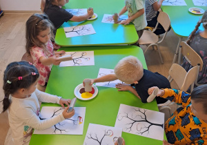 Odkrywcy ozdabiają drzewo kolorowymi listkami