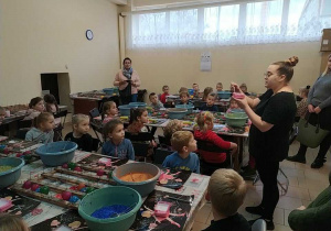 Dzieci podczas warsztatów słuchają instrukcji jak ozdobić własnoręcznie bombki
