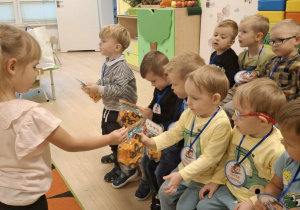 Dziewczynki wręczają upominki chłopcom z grupy Misie